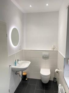 a white bathroom with a sink and a toilet at Moderne Wohnung in Unna Mitte in Unna
