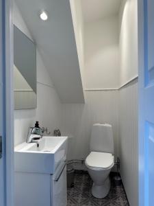 een badkamer met een wit toilet en een wastafel bij Smögens Gästgiveri in Smögen
