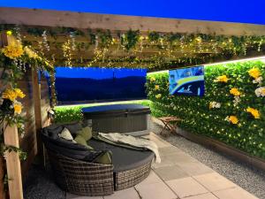 a patio with a garden with a couch and a tv at Tan Y Bryn Glamping in Conwy