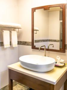 y baño con lavabo blanco y espejo. en Golden Bay Belize Hotel, en Ciudad de Belice