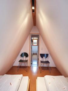 a room with two beds and two chairs in a attic at Nurdachhaus am Geyersberg in Freyung