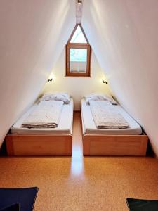 2 letti in una piccola camera con finestra di Nurdachhaus am Geyersberg a Freyung
