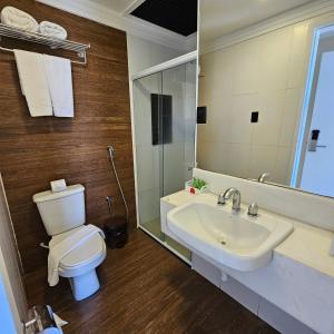 La salle de bains est pourvue de toilettes, d'un lavabo et d'un miroir. dans l'établissement Jatobá Praia Hotel, à Aracaju