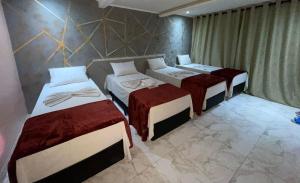 um quarto com três camas num quarto em HOTEL MODERNO em São Paulo