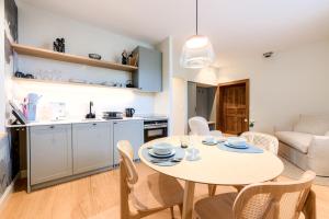 a kitchen and a dining room with a table and chairs at La Suite du Château - Domaine des Trois Tilleuls in Villers-la-Ville