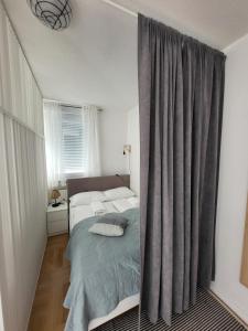 - une chambre avec un lit et un rideau gris dans l'établissement Studio Apartman Ana, à Zagreb