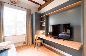 a bedroom with a large flat screen tv on a wall at Le Gîte du Domaine des Trois Tilleuls in Villers-la-Ville