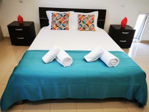 a bedroom with a large bed with towels on it at Alojamento M.A. in São Roque do Pico