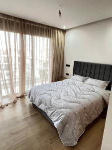een slaapkamer met een bed en een groot raam bij Appartement a agadir bay in Agadir