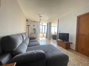 ein Wohnzimmer mit Couch und Flachbildfernseher in der Unterkunft APARTAMENTO ARENALES BELLAVISTASOLYMAR in Arenales del Sol