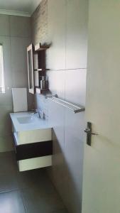 a white bathroom with a sink and a mirror at Secret guest house in Pietermaritzburg