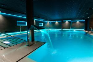 - une piscine avec des lumières bleues dans un bâtiment dans l'établissement Hotel Oh Nice Caledonia, à Estepona