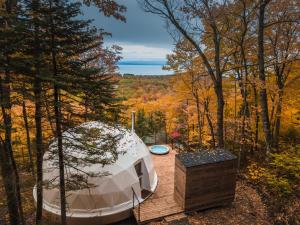 - une tente ronde sur une terrasse en bois dans les bois dans l'établissement Dômes Charlevoix, à Petite-Rivière-Saint-François