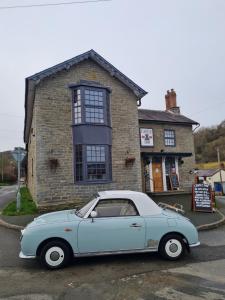 a blue car parked in front of a building at Castle Inn in Knighton