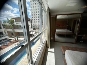 a room with a large window with a view of a building at Flat no Jade in Brasília
