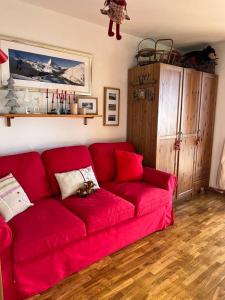 een rode bank in een woonkamer bij Nel cuore dell’Oasi Zegna in Bielmonte
