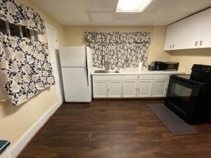 uma cozinha com um frigorífico branco e um lavatório em Lasalle Getaway Home! em Niagara Falls