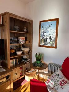een woonkamer met een bank en een boekenplank bij Nel cuore dell’Oasi Zegna in Bielmonte