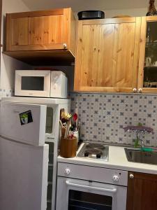 een keuken met een wit fornuis en een magnetron bij Nel cuore dell’Oasi Zegna in Bielmonte