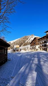 een met sneeuw bedekte straat met gebouwen en een berg bij Nel cuore dell’Oasi Zegna in Bielmonte