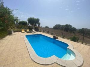 a large swimming pool in a patio with at Serra do Caldeirao Villa with Pool in Curvatos