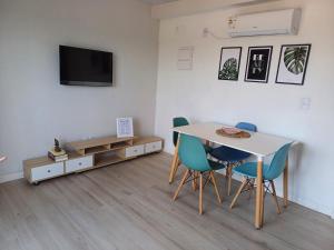 a room with a table and chairs and a tv at La Demorada, cómoda casa en entorno natural in Mercedes