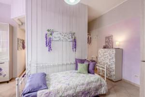 een slaapkamer met een bed met paarse en groene kussens bij 15 min da Malpensa - Free Parking & Self Check-In in Cassano Magnago