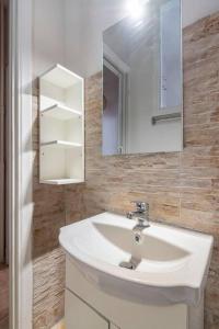 een badkamer met een witte wastafel en een spiegel bij STM Monastiraki Acropolis Apt in Athene
