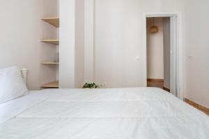 a large white bed in a white bedroom at STM Monastiraki Acropolis Apt in Athens
