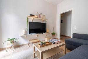 a living room with a couch and a tv at STM Monastiraki Acropolis Apt in Athens