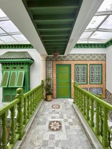 un pasillo con una puerta verde en una casa en Dar Waya en Mahdia