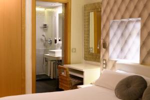 a bedroom with a bed and a bathroom with a shower at Hotel De Martin in San Lorenzo de El Escorial