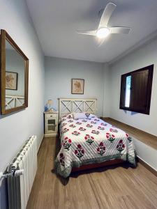 a bedroom with a bed and a ceiling fan at LOS PINOS DE NAVALFRESNO in Aracena