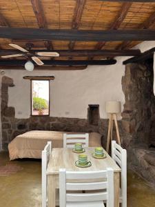 a room with a table and chairs and a bed at La Hoyada in Tilcara