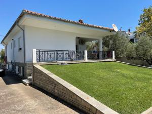 a house with a balcony and a yard at My House in Paralia Messi in Aroyí