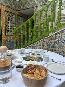 una mesa con platos de comida y una cesta de pan en Dar Waya en Mahdia