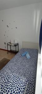uma cama num quarto com uma almofada azul em Casa das Tílias em Coimbra