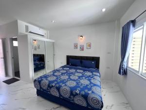 Un dormitorio con una cama azul y blanca en una habitación en Banrimkhao(บ้านริมเขา)bangtao, en Chalong 