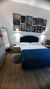 una camera con letto blu e quadri appesi al muro di H22 Hotel a Napoli