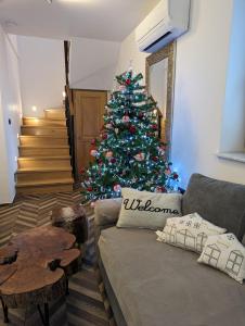 a christmas tree in a living room with a couch at MY TIME Holiday House with sauna in Zgornje Gorje