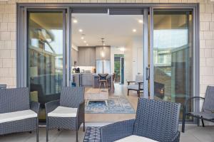 a patio with chairs and a table and a kitchen at Seas The Day Saratoga at THE BEACH HOUSE in Campbell River +43 photos