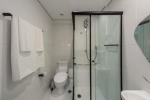 a bathroom with a toilet and a glass shower at Charlie Panorama Butantã in São Paulo