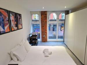 a bedroom with a white bed and a window at Northern Quarter Flat in Manchester