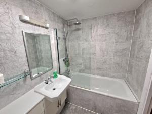 a bathroom with a sink and a tub and a shower at Northern Quarter Flat in Manchester