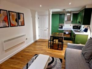 een woonkamer met groene kasten en een tafel bij Northern Quarter Flat in Manchester