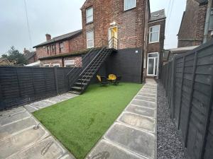 a backyard with a staircase leading up to a house at Super Stylish Apartment in Urmston Flat 3 in Urmston