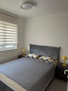 a bedroom with a large bed with a window at Apartment Rhea SelfCheckIn Garage Loggia New in Zagreb