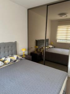 a bedroom with two beds and a large mirror at Apartment Rhea SelfCheckIn Garage Loggia New in Zagreb