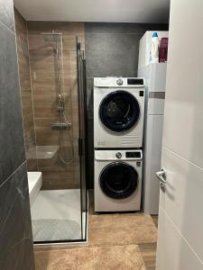 a washer and dryer in a bathroom with a shower at Apartment Rhea SelfCheckIn Garage Loggia New in Zagreb