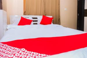 Una cama roja y blanca con almohadas rojas. en OYO Hotel Sonar Gaon, en Agartala